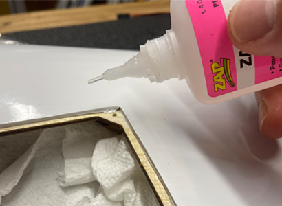 Image of modeler applying CA to an ARFs aileron or flap servo door/cover.