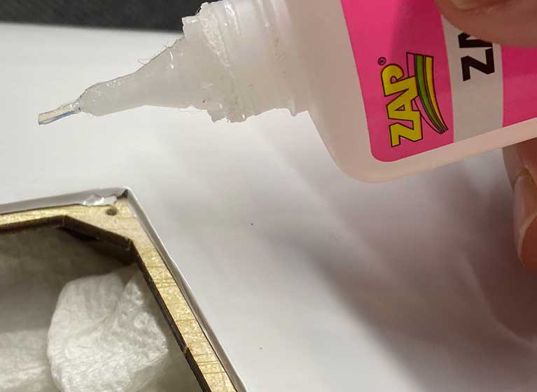 Image of modeler applying CA to an ARFs aileron or flap servo door/cover.